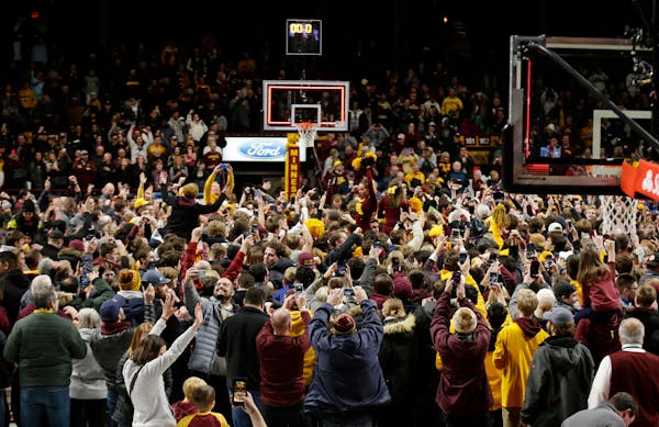 Minnesota fans storm the court after an upset victory over Ohio State