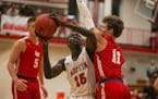 Austin sophomore Victor Idris (15) found his path to the basket blocked by Lakeville North's Jordan Wall (11) during the Packers' 55-50 victory. Photo