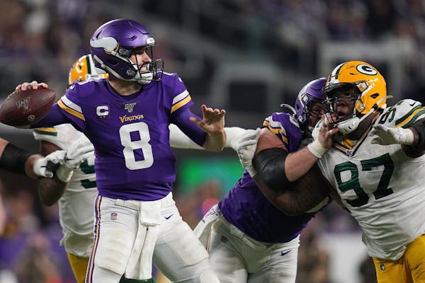 Minnesota Vikings quarterback Kirk Cousins (8) threw under pressure from Green Bay Packers nose tackle Kenny Clark (97) in the fourth quarter.