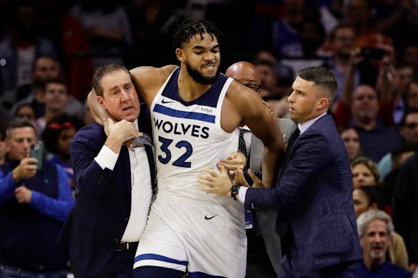 Wolves assistant coach Bryan Gates, left, tried with coach Ryan Saunders to get Karl-Anthony Towns off the floor following Towns’ altercation with P