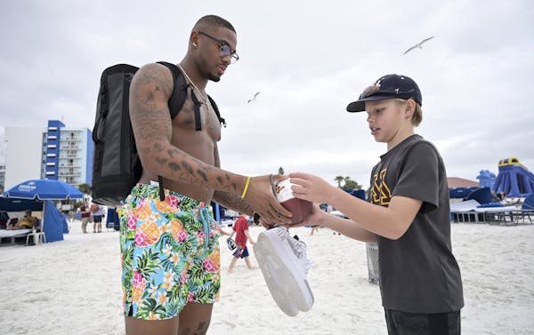 Gophers wide receiver Rashod Bateman signed a football for Isaac Harder, 11, of Rosemount during the Outback Bowl’s Beach Day on Monday in Clearwate