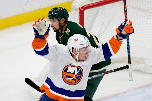 New York Islanders' Casey Cizikas celebrates a goal as Wild defenseman Matt Dumba skates away in the third period