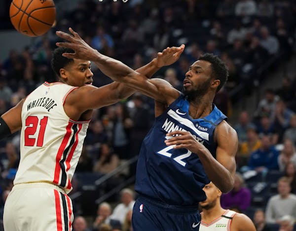Timberwolves forward Andrew Wiggins passed off to a teammate around Trail Blazers center Hassan Whiteside in the second quarter.