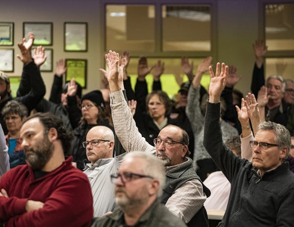 Those who approved a motion to refuse refugee resettlement raised their hands in the overcapacity crowd in attendance earlier this month in Minnesota'