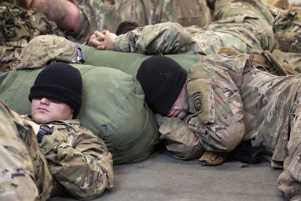 This photo provided by the U.S. Army, two 1st Brigade Combat Team, 82nd Airborne Division Paratroopers rest before deploying to the U.S. Central Comma