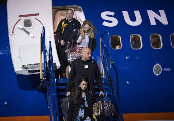 Preceded by his wife, Heather, Gophers head coach P.J. Fleck descended the stairs after arriving at Sun Country's hangar with his team Wednesday night