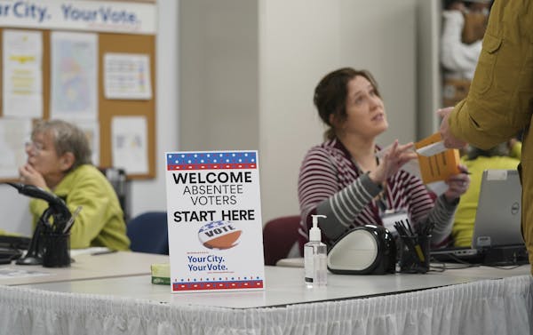 A poll worker spoke with a voter as the Minneapolis Early Voting Center opened Jan. 17.