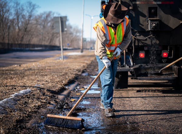 Street service worker Bradley Therres smoothed asphalt over a pothole on Shepard Road in St. Paul in March.