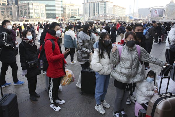 People wearing masks head Wednesday for Beijing Station in Beijing, China. 3M has workers on overtime to meet the demand of people wanting protective 