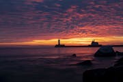 The first sunrise of 2020 brought deep orange and pink colors over the Duluth Harbor North and South Breakwater Lighthouses in Duluth, MN on January 1