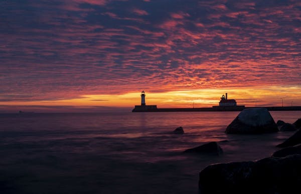 The first sunrise of 2020 brought deep orange and pink colors over the Duluth Harbor North and South Breakwater Lighthouses in Duluth, MN on January 1