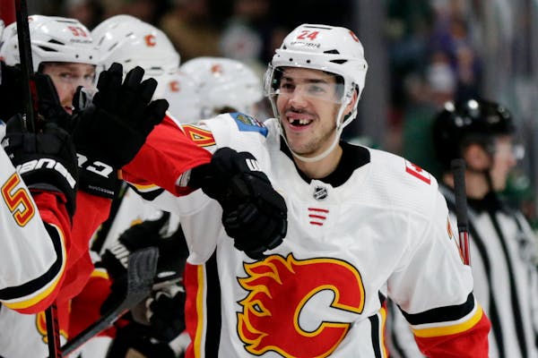 Calgary defenseman Travis Hamonic is congratulated by the bench after scoring a goal against the Wild in the first period