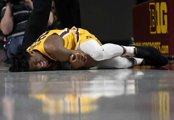 Minnesota center Daniel Oturu (25) lays on the court after being injured on a play against the Michigan in the second half.
