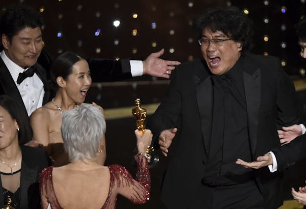 Bong Joon Ho, right, reacts as he is presented with the award for best picture for "Parasite" from presenter Jane Fonda at the Oscars on Sunday, Feb. 