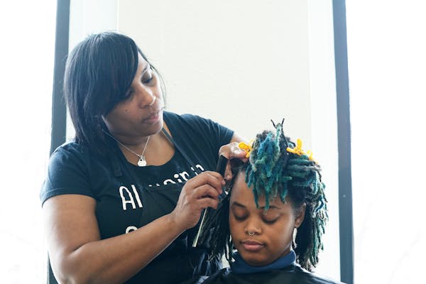 Stylist Erika Carter worked on AK Wright’s hair Wednesday morning at the Beauty Lounge in south Minneapolis.