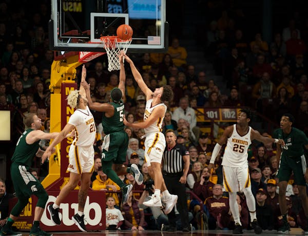 Michigan State guard Cassius Winston scored in the first half between the defense of Gophers forward Jarvis Omersa, left, and guard Gabe Kalscheur. Wi