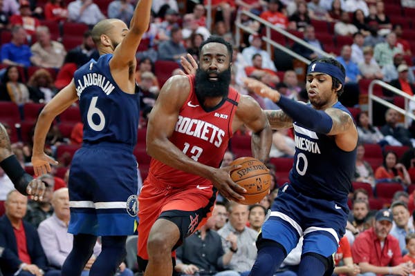 Rockets guard James Harden drives to the basket between Timberwolves guard Jordans McLaughlin (6) and D'Angelo Russell (0)