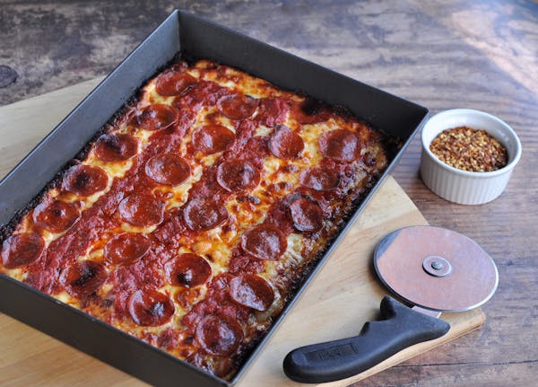 Toppings for Detroit-style pizza are usually under the cheese and sauce to allow the thick crust to bake.