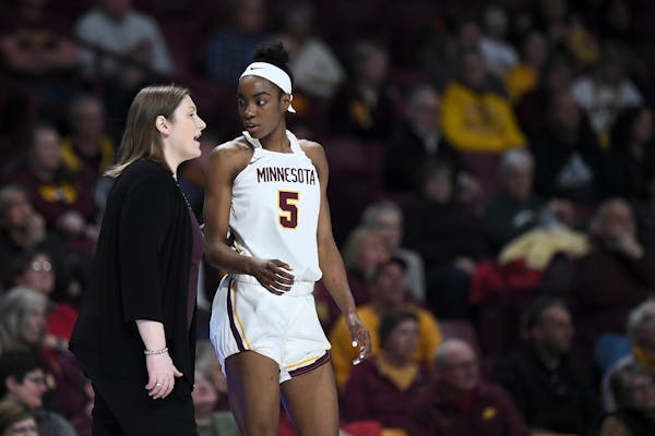 Gophers coach Lindsay Whalen talks things over with forward Taiye Bello in the second half against Iowa