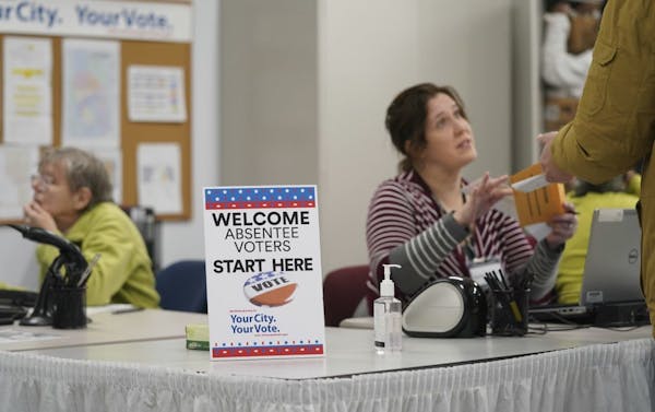 A poll worker spoke with a voter as an Early Voting Center opened in Minneapolis on Jan. 17, 2020.