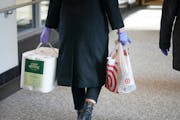 A rubber-gloved shopper carried paper towels and other supplies recently through the downtown Minneapolis skyway.