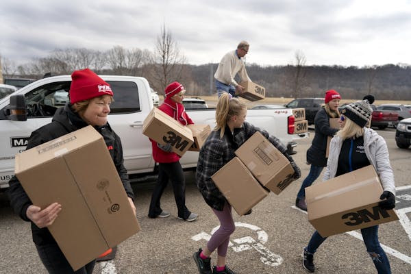 Registered nurse Kim Lutes left, and others carried 1,200 N95 masks donated by Rich Forstner, president of White Bear Lake contracting firm Mavo Syste