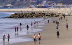 Beachgoers are seen at Venice Beach, Saturday, March 21, 2020, in Los Angeles. Traffic would normally be bumper-to-bumper during this time of day on a