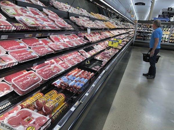A shopper surveys the overflowing selection of packaged meat in a grocery early Monday, April 27, 2020, in southeast Denver. With closures in meat pro