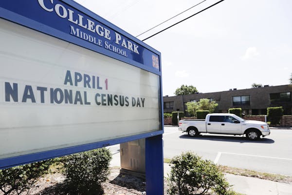 In this Tuesday, March 24, 2020 photo, a sign at a middle school in Orlando, Fla., reminds residents that April First is census day. The coronavirus h