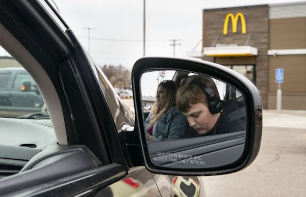 Colton Rebarich worked on choir homework while his mom, Nancy, checked her phone while parked outside a McDonalds in Virginia, Minn. They go there twi
