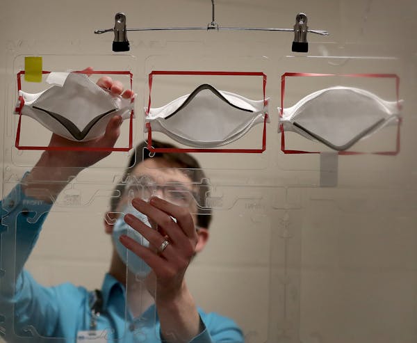 Dan Cates, an infection prevention practitioner at Regions Hospital, demonstrated how used 3M N95 masks will be places onto plastic racks to be steril