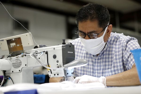 Jose Pedro Sanchez,a seamstress at Blue Delta Jeans, sews together a face guard at the jeans manufacturing company's site in Shannon, Miss.