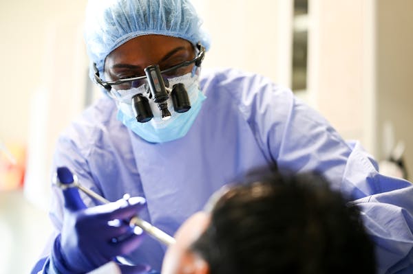 Dr. Geetha Damodaran performed an emergency tooth extraction Thursday at Hope Dental Clinic in St. Paul.