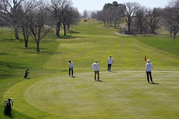 Golfers kept more than the recommended social distance from one another as they putted on the first hole Saturday at Columbia Golf Club.