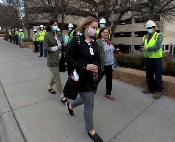 Xcel Energy crew members greeted healthcare workers during the early morning shift change outside Regions Hospital Wednesday.