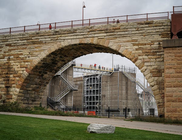 A group of visiting students crossed the bridge at the opening of the lock and dam in Minneapolis. Plans to transform the lock and dam beside the Ston