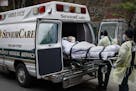 A patient is loaded into an ambulance by emergency medical workers outside Cobble Hill Health Center, Friday, April 17, 2020, in the Brooklyn borough 