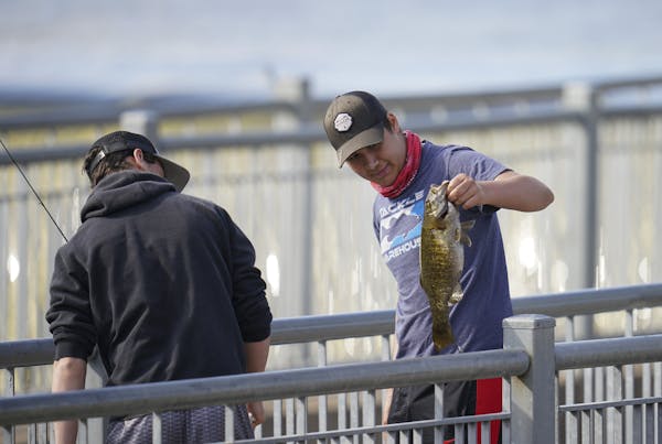 Daniel Belous, 15, held up a smallmouth bass he’d just caught Wednesday night at the Rum River Dam in Anoka He was released it after measuring it an