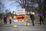 Pedestrians walked near a “road closed” sign as they walked around Lake Harriet in Minneapolis recently.