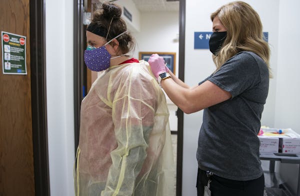 Beth Thomsen was suited up with full-body PPE by Noel Salo before going into an exam room to administer flu, COVID-19 and RSV tests to a 2-month-old c