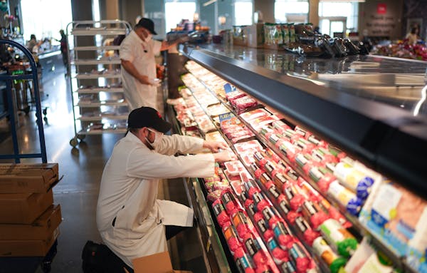 Billy Otero, left, and Michael Olson stocked the meat shelves at Cub Foods near 46th Street and Hiawatha Avenue in Minneapolis.