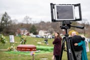 Guests mourn during a live-streamed funeral in March. The pandemic has made in-person funerals difficult to hold and many families are struggling with