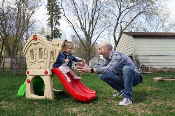 Brendan Kennealy caught his daughter Hazel, 2, as she went down a small slide in the backyard of their home Friday.