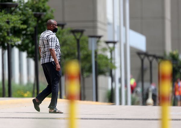 A worker is seen outside Amazon.com Inc.’s giant fulfillment center Tuesday in Shakopee, where at least 88 of its approximately 1,000 workers testin