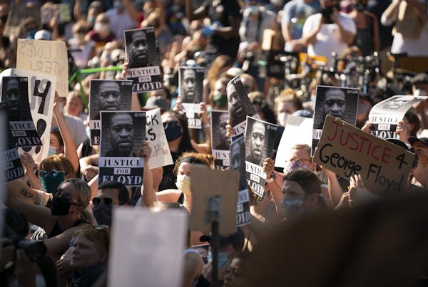 The crowd held posters with the image of George Floyd's face while listening to speakers in front of the Governor's residence.