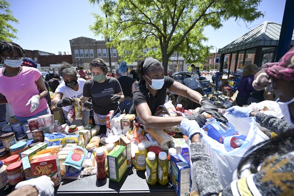 Cathy Burns, an employee with the city of Minneapolis, handed out food items while volunteering in north Minneapolis on May 30.