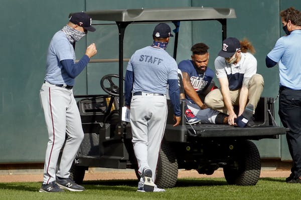 Twins manager Rocco Baldelli, left and coach Tony Diaz, second from left, watch as assistant athletic trainer Matt Biancuzzo, second from right, stead