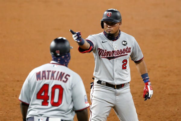 The Twins' Luis Arraez acknowledges teammates in the dugout after hitting a two-run single during the seventh inning