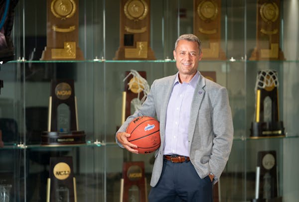 Athletic Director Phil Esten stood for a photo in front of the trophy case at the University of St. Thomas