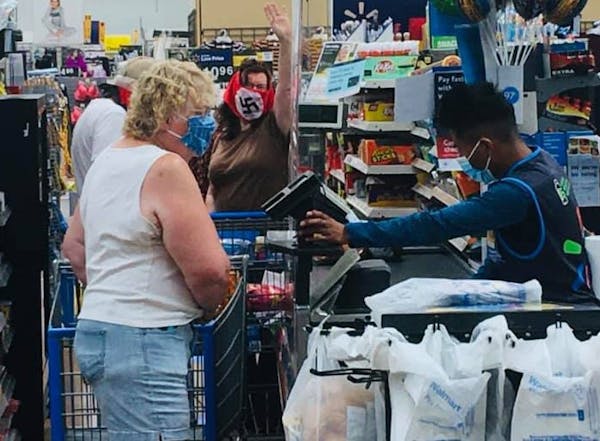 A couple wearing swastika masks (behind the front customer) made defiant gestures at other shoppers who reacted negatively to their masks on Saturday 